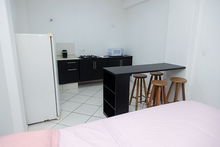 Estúdio espaçoso com sacada e cama king no centro
